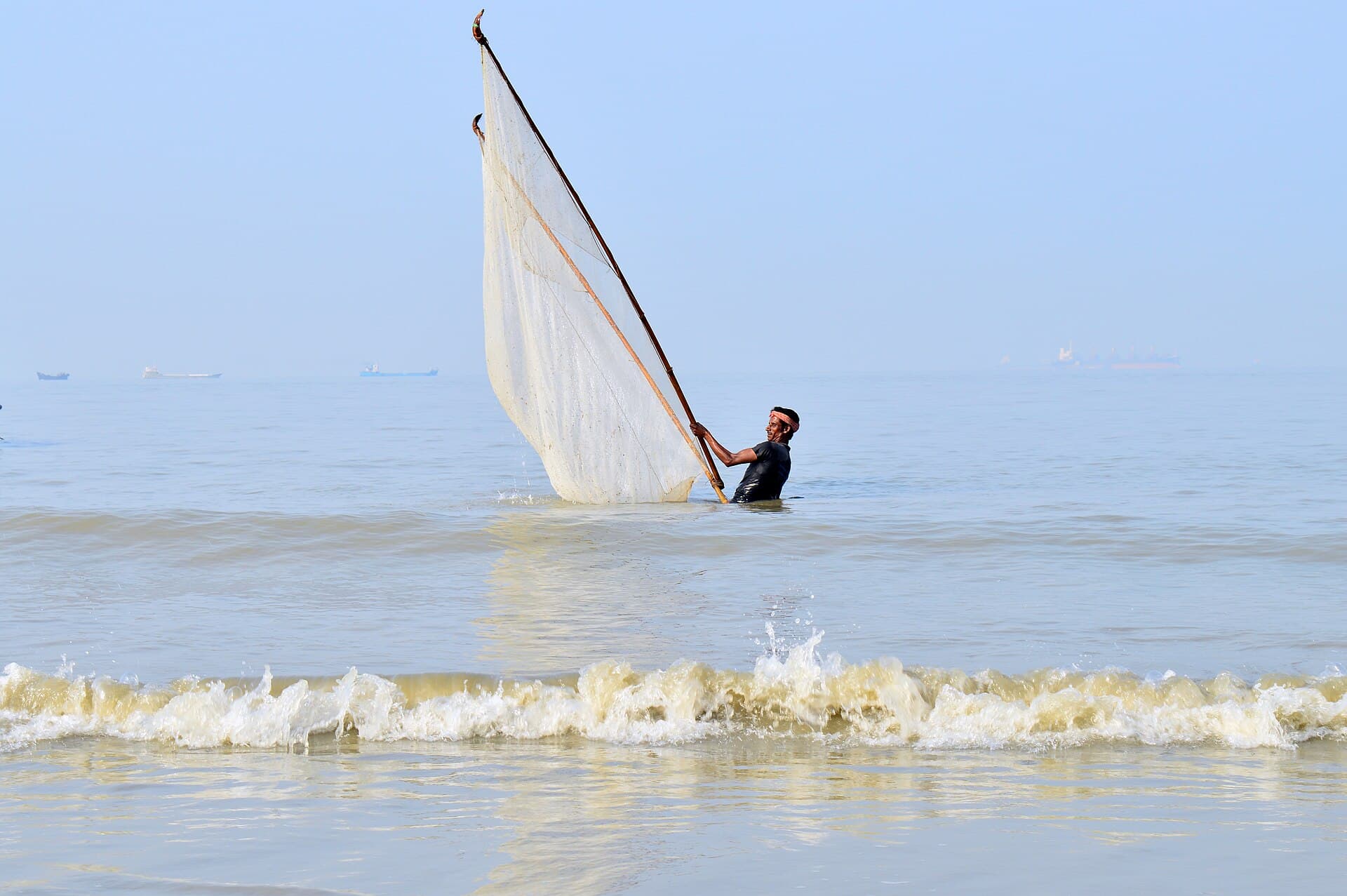 Fishermen washing a net on the sands at Patenga, Chattogram