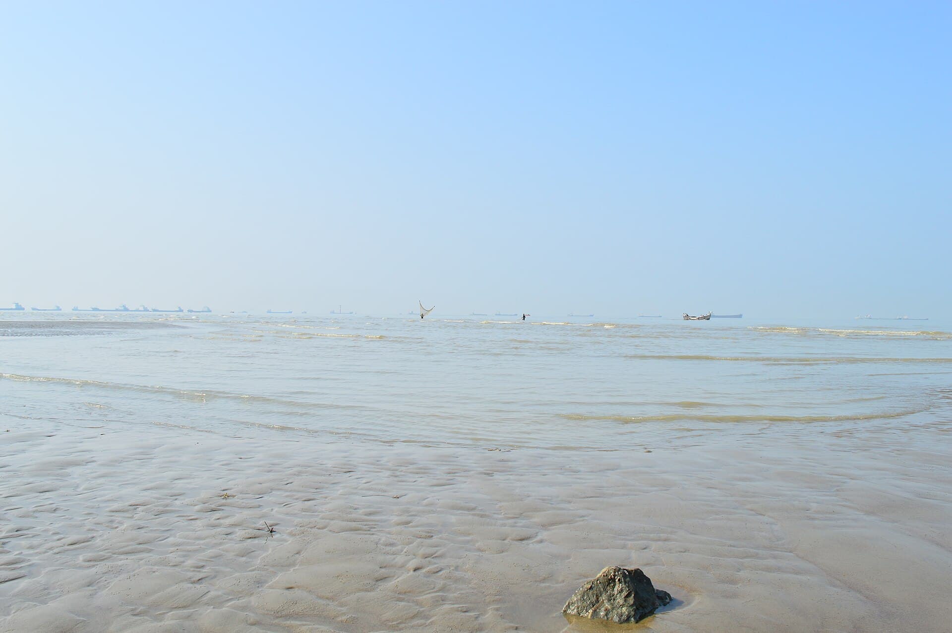 Crowds and concrete blocks along the shore at Patenga sea beach, Chattogram